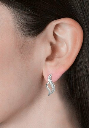 Orecchini d'argento a forma di onda con superficie testurizzata e accenti scintillanti. Progettati per pendere al di sotto del lobo dell'orecchio, con una finitura lucida.