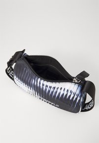 Borsa a pochette zip in bianco e nero con un design texturizzato, caratterizzata da un esterno a motivi, una cerniera robusta e una tracolla in tessuto impresso con il marchio.