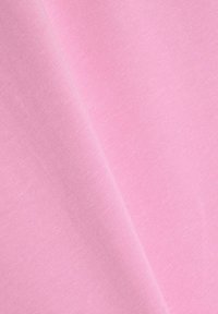 Tissu rose clair avec une texture lisse, présentant un léger éclat et un motif de tissage uniforme, plié à un angle.