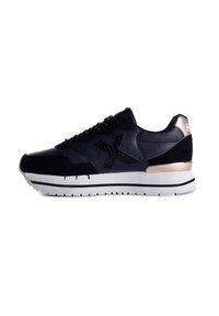 Schwarze Sneakers mit Leder- und Wildledertexturen, ausgestattet mit einem markanten schwarzen Logo, metallischen goldenen Akzenten und einer weißen Gummisohle mit schwarzen Streifen.