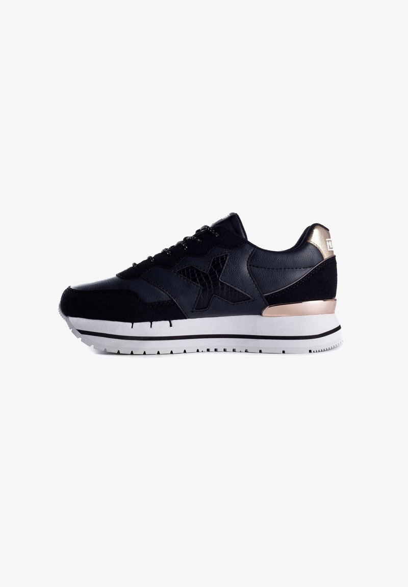 Schwarze Sneakers mit Leder- und Wildledertexturen, ausgestattet mit einem markanten schwarzen Logo, metallischen goldenen Akzenten und einer weißen Gummisohle mit schwarzen Streifen.
