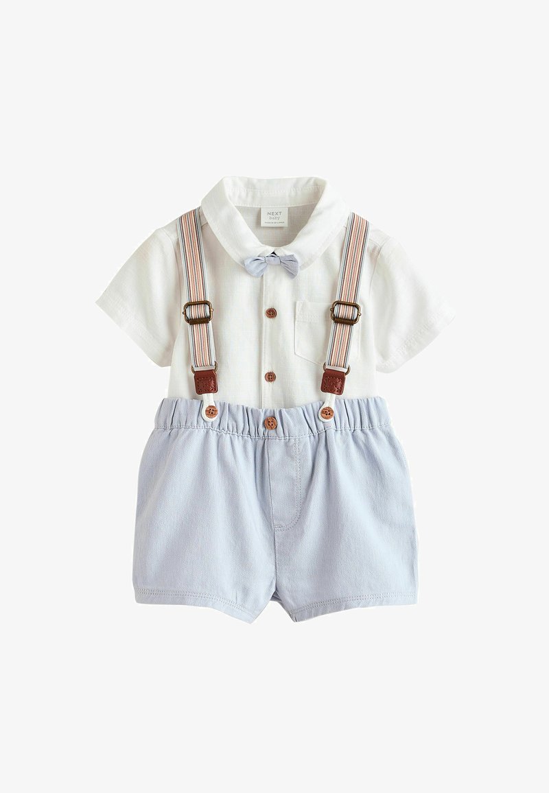 Chemise blanche à manches courtes avec des boutons marron, un nœud papillon bleu clair, un short bleu à taille élastique et des bretelles rayées fixées au short.