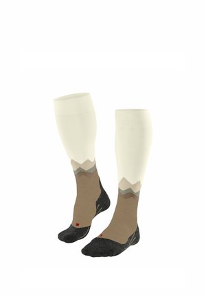 Een paar kniehoge sokken met een crèmekleurig bovenstuk, een bruin en grijs bergachtig patroon, en zwarte teen- en hielstukken met de labels L en R.