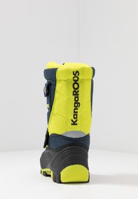 Hochschnittstiefel aus dunkelblauem und leuchtend gelbem Stoff. Verfügt über einen gepolsterten Kragen, einen verstellbaren Riemen und eine strukturierte Gummisohle.