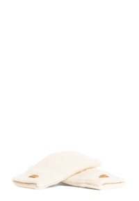 Gant de doigts crème en tricot doux, présentant une texture côtelée et un petit patch en cuir marron sur un des gants.