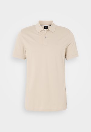 Polo shirt beige in cotone, con colletto a tre bottoni, maniche corte e un logo ricamato discreto sul petto.