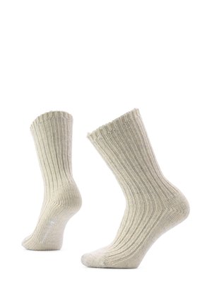 Pair of beige ribbed knit wool socks shown upright with heels raised and toes pointed down against white background.