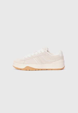 White suede and leather sneaker with a gum rubber outsole, featuring round laces, side branding, and a minimalist design.