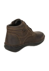 Botín de cuero marrón hasta el tobillo con puntera redondeada, superficie texturizada, costuras en contraste y una suela de goma negra. Presenta un diseño con cordones.