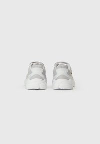 Sive tenisice za trčanje s mrežastim i sintetičkim gornjim dijelom, podstavljenim bijelim potplatom i Lacoste logotipom na peti. Minimalistički dizajn i lagane su.