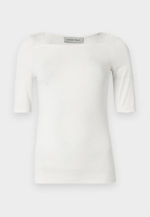 Λευκό κοντομάνικο τοπ με τετράγωνη λαιμόκοψη, κατασκευασμένο από λείο ύφασμα, με διακριτικές ραφές στους ώμους και τις πλευρές.