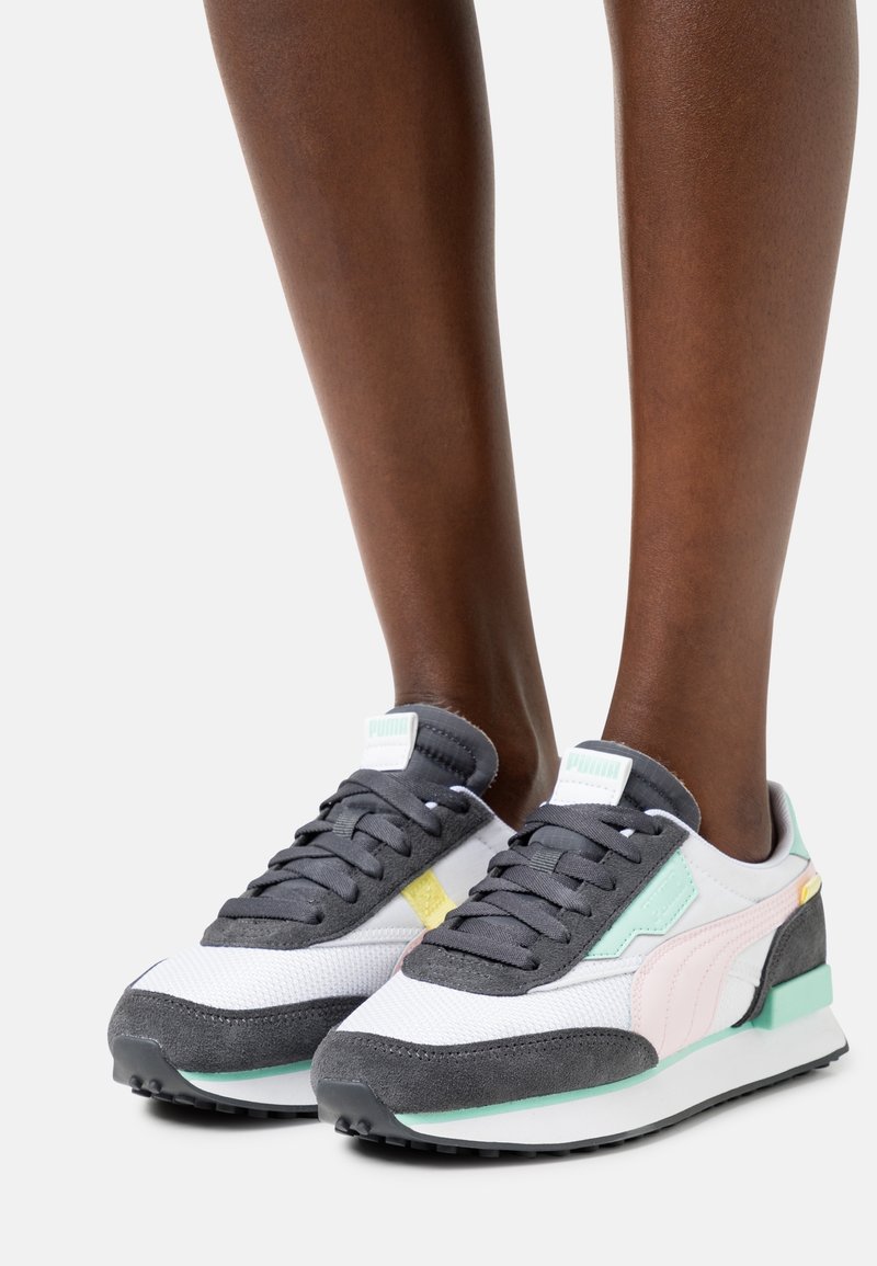 Baskets Puma combinant des matériaux gris, blanc et vert menthe, avec des textures en daim et en mesh, des lacets plats et un accent jaune.
