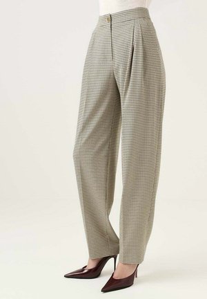 Beige geruite broek met hoge taille en plooien, knoopsluiting, gedragen met donkerbordeauxrode pumps met spitse neus, op een lichte achtergrond.