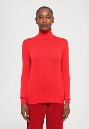 Red turtleneck sweater with long sleeves, ribbed hem, and cuffs; made from a textured knit fabric. Styled with red pants.