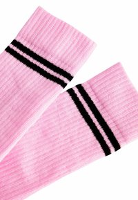 Calze rosa a lunghezza ginocchio realizzate in tessuto a coste, con due strisce nere nella parte superiore. Texture morbida e colore uniforme in tutto.