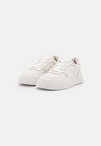 Vita sneakers med slät läderöverkägla, rund tå, perforerat mönster, platta skosnören och tjocka, strukturerade gummisula.