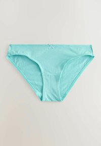 Culotte bikini en coton bleu clair pour femme avec un petit nœud en tissu centré à la ceinture, posée à plat sur un fond uni.