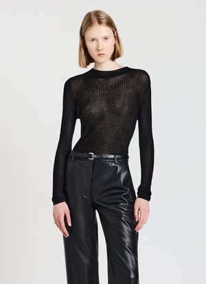 Top lungo a maniche lunghe nero a coste realizzato in materiale trasparente, abbinato a pantaloni in pelle nera a vita alta con una texture liscia e cintura.