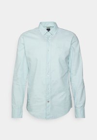 Camicia azzurro chiaro a maniche lunghe con bottoni, realizzata in un tessuto morbido, dotata di colletto button-down e discreto logo del marchio sul petto.