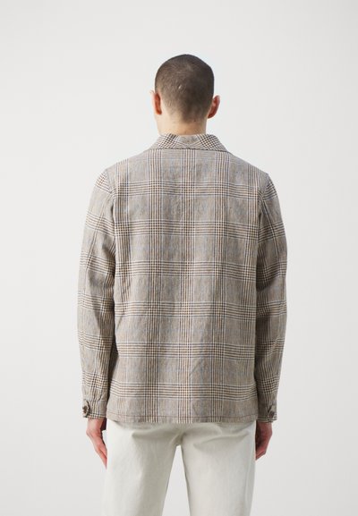 Plaid shirt in brown and beige tones, textured fabric, buttoned cuffs, and a notch collar. Back view shows check pattern and tailored fit.