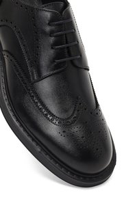 Zwarte leren kleed schoen met een gladde afwerking, gedetailleerd brogue-patroon, zes oogjes en een duurzame rubberen zool.