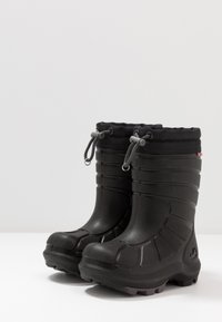 Botas pretas impermeáveis com um acabamento texturizado, apresentando um topo com cordão e uma sola robusta para aderência. Ponta arredondada e altura até a metade da panturrilha.