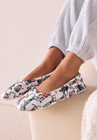 Mustritega libistatavad sussid, valge kangaga, millel on värvikirevad loomade illustratsioonid. Ümar varvas ja paindlik konstruktsioon mugavuse tagamiseks.