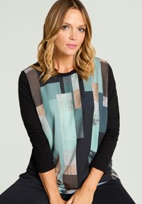 Langärmliges Oberteil mit schwarzem Körper und einem geometrischen Muster in Türkis, Beige und Grau auf der Vorderseite, aus glattem Stoff gefertigt.