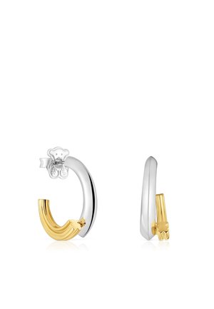 Pendientes tipo huggie con un diseño de plata pulida y oro texturizado. Destacado acento de oso en la base. Forma ovalada con un acabado moderno.