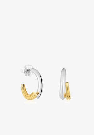 Boucles d'oreilles Huggie avec un design en argent poli et en or texturé. Accent de ours distinctif sur le clou. Forme ovale avec une finition moderne.