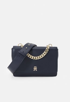 Rechthoekige handtas van marineblauw leer met brede band en gouden kettingdetail, voorzien van een klein gouden logo op de voorflap.