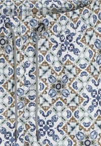 Shorts de bain en tissu blanc avec un motif floral et géométrique complexe en bleu et marron ; dotés d'un cordon de serrage avec des accents noirs et blancs.