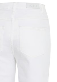 Jean en denim blanc avec une taille haute, des poches arrière et une étiquette logo ICHI sur la taille. Texture lisse avec des détails cousus.