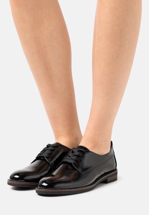 Chaussures en cuir verni noir avec orteils ronds, design à lacets, dessus texturé et talon en bois bas. Finition lisse avec des lacets contrastants.