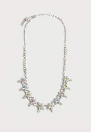 Sidabrinė grandinėlė su žvaigždės formos žiedais, kiekvienas papuoštas blizgančiais rožiniais, mėlynais ir geltonais brangakmeniais, ir maža rožinė pakabukė netoli užsegimo.