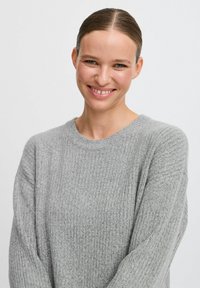 Maglione grigio a coste con scollatura a girocollo e maniche lunghe, caratterizzato da una morbida texture e una vestibilità rilassata.