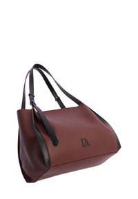 Bolso de cuero marrón con acentos negros, de forma relajada y con un acabado texturizado sutil. Presenta correas ajustables y un detalle del logo.