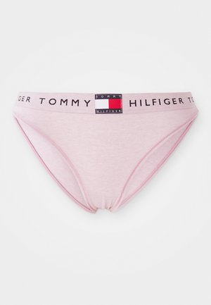 Light pink cotton bikini underwear with a black elastic waistband featuring the text "TOMMY HILFIGER" and a logo patch. Simple, low-rise design.