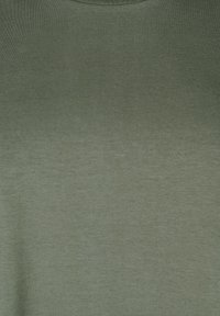 Grøn crew-neck t-shirt lavet af glat stof, der viser en let struktureret overflade med subtile farvevariationer. 