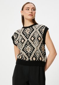 Suéter de punto negro sin mangas con un patrón de diamantes florales en beige y blanco, con un cuello redondo acanalado y dobladillo.