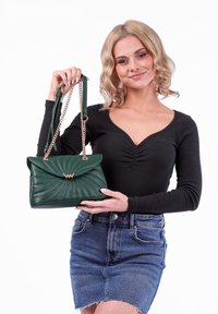 Zelená kabelka z umělé kůže s prošívaným vzorem, zlatými detailem a řetízkovým popruhem. Obsahuje překlopný vršek a texturovaný povrch.