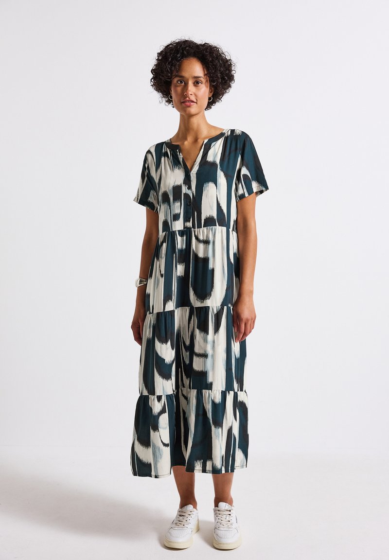 Abito maxi stampato in tonalità di teal, crema e nero, con maniche corte, scollatura a V e design a volant con vestibilità ampia.