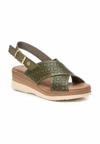 Infradito verde oliva con tomaia in pelle perforata, cinturino regolabile con fibbia, base leggera marrone chiaro a forma di zeppa e suola bianca testurizzata.