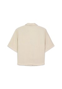 Maglietta beige a maniche corte con colletto, vista da dietro, caratterizzata da un taglio ampio e una vestibilità rilassata.