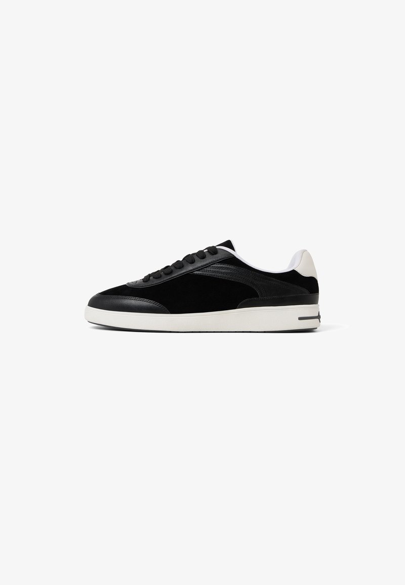 Czarne sneakersy z połączenia zamszu i skóry, niskoprofilowy fason, biała podeszwa oraz czarne sznurówki z minimalnymi akcentami.