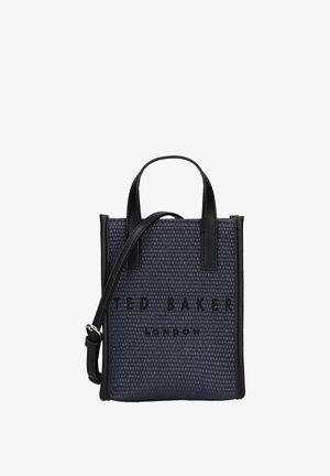 Small navy textured tote bag with black leather handles and strap, featuring "Ted Baker London" embossed on front.