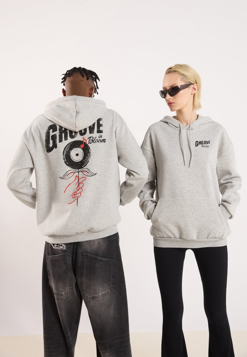 Gray hoodies feature printed designs: one with "GROOVE in Bloom" and a vinyl record graphic on the back, another with a smaller logo on the front.