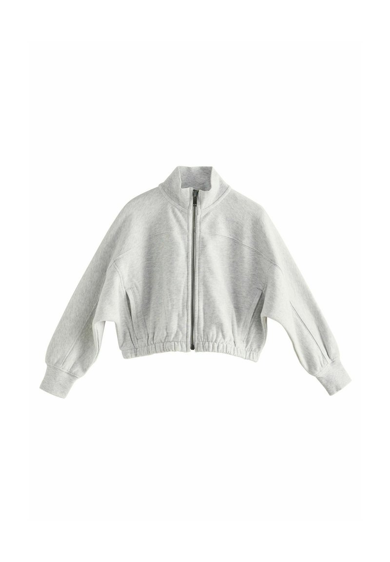 Sweatshirt gris coupé avec un col montant, fermeture éclair frontale et poignets élastiques. Fabriqué en tissu doux avec une surface légèrement texturée.