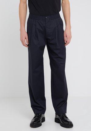 Navy trousers with an elastic waistband and pleats, made of lightweight fabric. Smooth texture with side pockets and a relaxed fit.