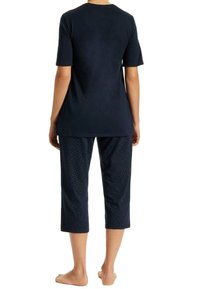 Navy cotton t-shirt with short sleeves and round neckline paired with cropped pants featuring white polka dots on a navy background.